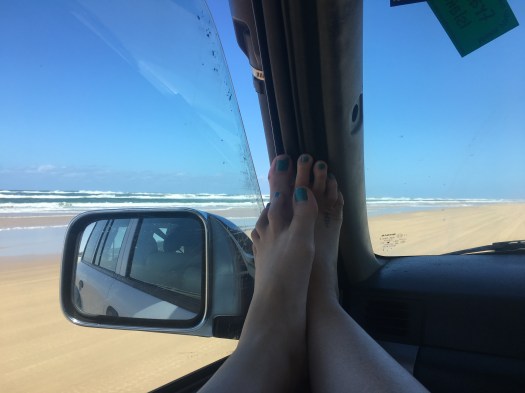 Feet on the dashboard while four wheel driving on the beach at Fraser Island